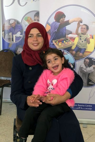 A photo of a smiling Basma mom with child.