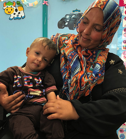A mother and child waiting for treatment at Ahli Hospital.