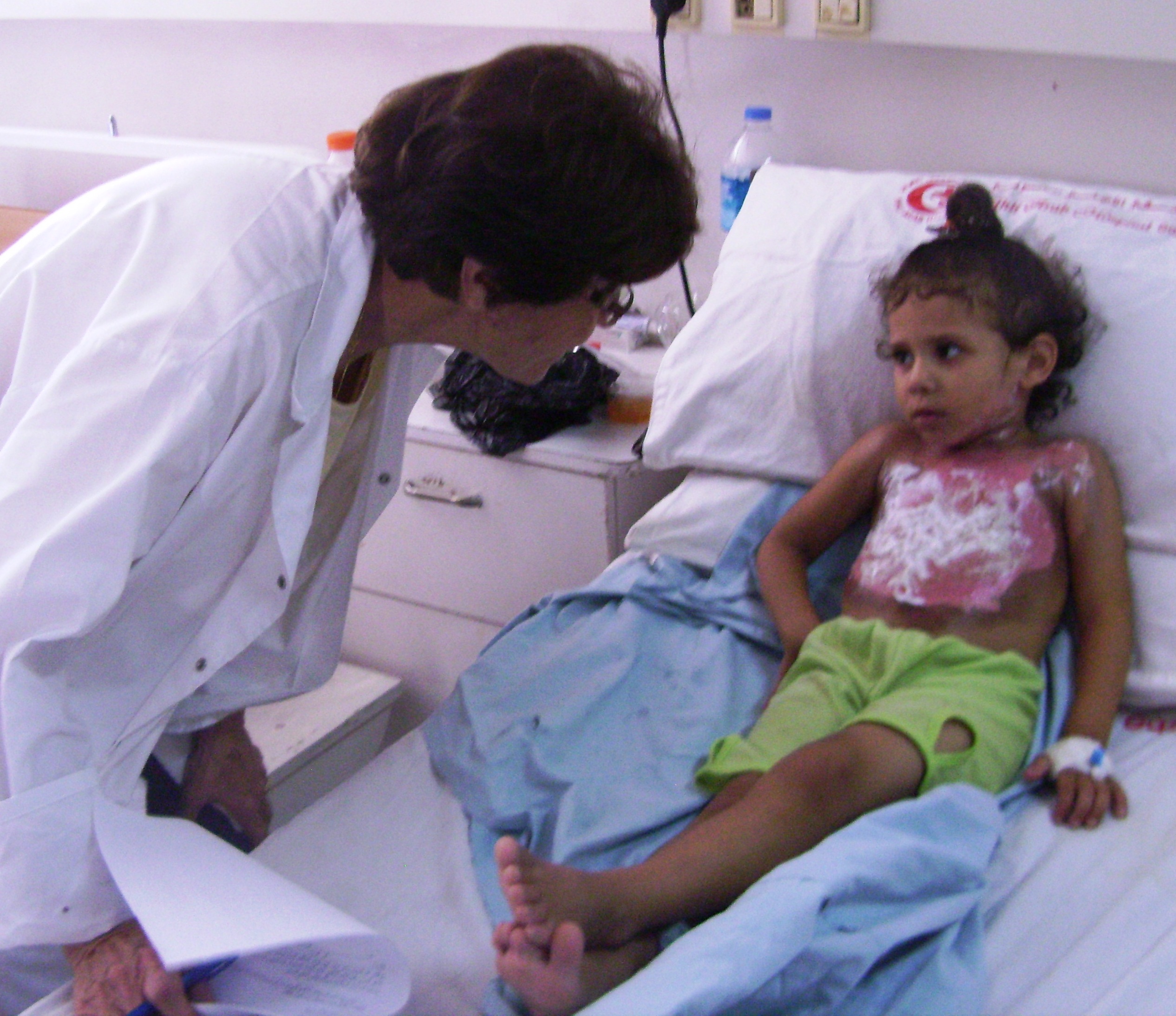 A photo of a doctor talking with her young patient at Ahli Arab Hospital