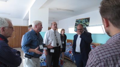 A photo of AFEDJ Trustees talking while viewing an dormitory facility.