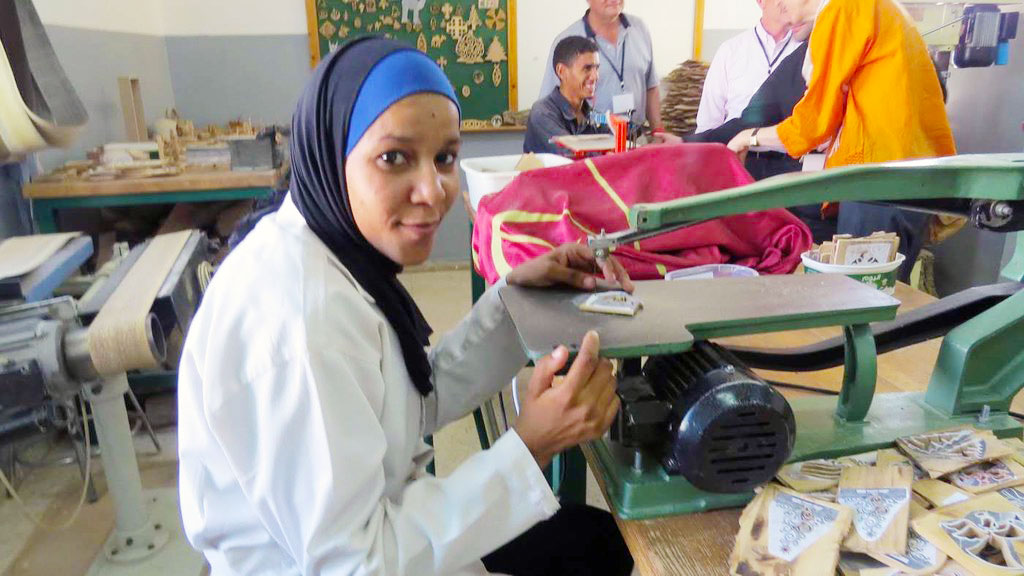 A photo of a woman working on a jig saw at Jofeh Community Rehabilitation Center, in Jordan