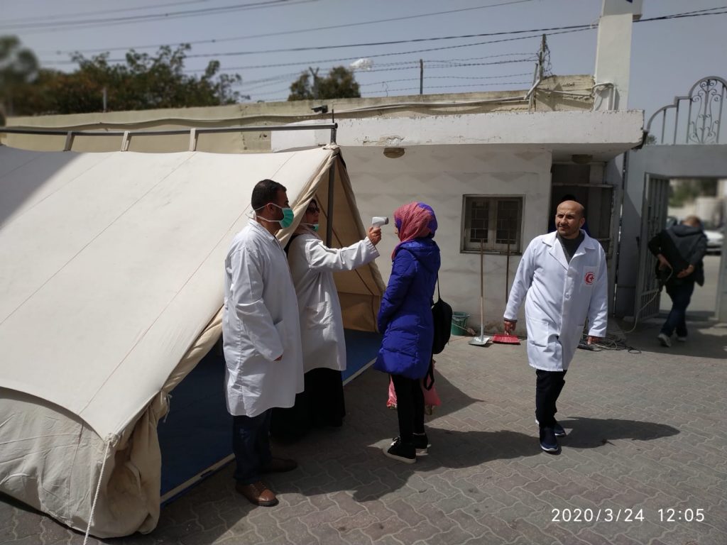 A patient is checked for fever at a triage tent at Ahli Arab Hosptial in Gaza City