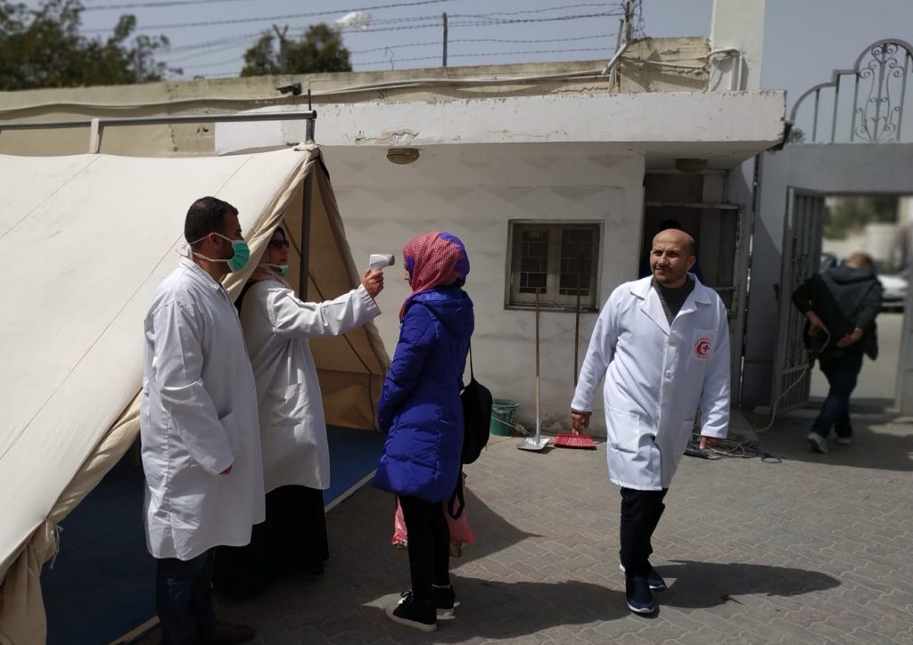 A patient is checked for fever at a triage tent at Ahli Arab Hosptial in Gaza City